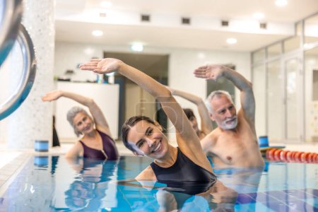 Téléchargez les photos : Aérobic aquatique. Adultes âgés dans la piscine pendant les cours d'aérobic aquatique - en image libre de droit