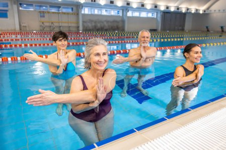 Téléchargez les photos : Aérobic aquatique. Groupe de personnes âgées ayant une classe d'aquagym - en image libre de droit
