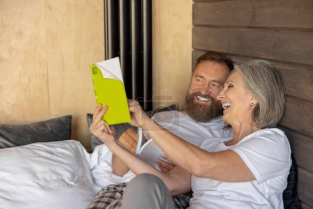 Photo for Reading together. Man and woman spending time at home with a good book - Royalty Free Image