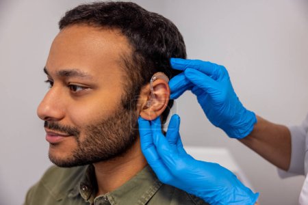 Foto de Audífono. otorrinolaringólogo implementando audífono al oído pacientes - Imagen libre de derechos