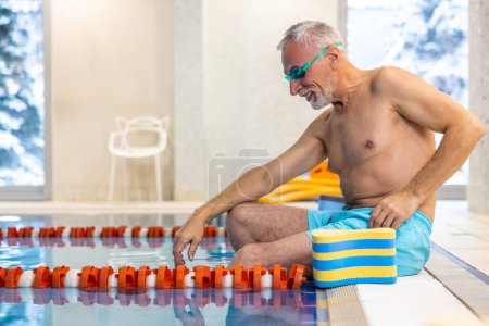 Téléchargez les photos : Un nageur senior. Maillot de bain sénior en lunettes de sport nautique à la piscine - en image libre de droit