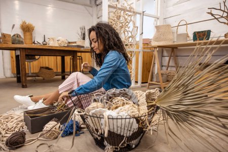 Photo for Macrame tools. Young woman looking at macrame tools with interest - Royalty Free Image