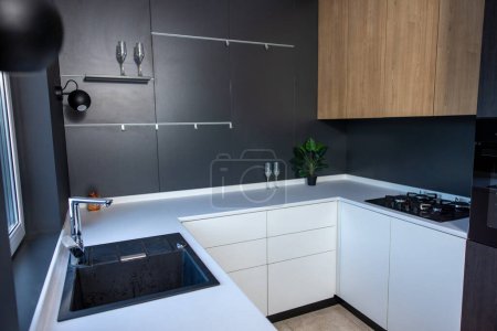 Téléchargez les photos : Cozy kitchenette moderne avec les armoires blanches et les murs noirs décorés dans le style minimaliste - en image libre de droit