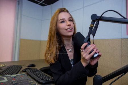 Téléchargez les photos : La radio. Jolie fille blonde avec microphone au studio de radio - en image libre de droit