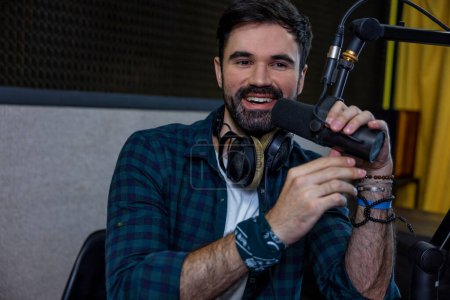 Photo for Radio dj. Dark-haired young man with a microphone in hand - Royalty Free Image