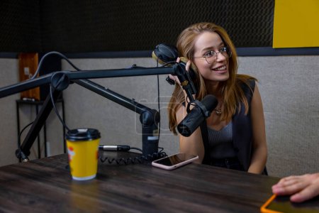 Photo for Studio guest. Ginger smiling young woman at the radio studio - Royalty Free Image