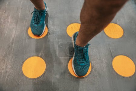 Photo for In a gym. Close up of a mans legs on marking cirlces in a gym - Royalty Free Image