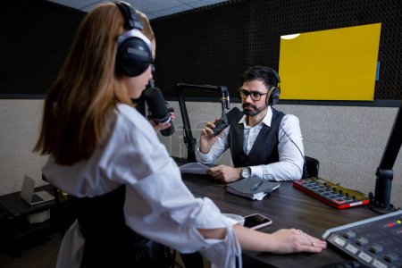Foto de Dialogo. Radio DJ hablando con un joven cantante en la estación de radio - Imagen libre de derechos