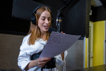 Photo for At the radio studio. Young girl reading text from paper - Royalty Free Image