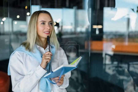 Photo for Planning. Blonde businesswoman writing something on a glass board - Royalty Free Image