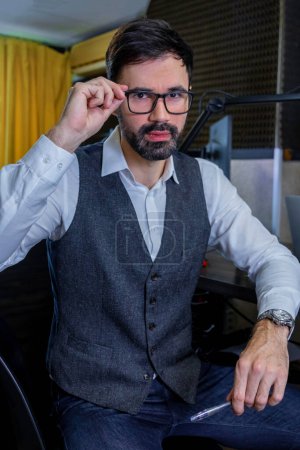 Photo for At the radio studio. Bearded dark-haired man looking at the camera - Royalty Free Image