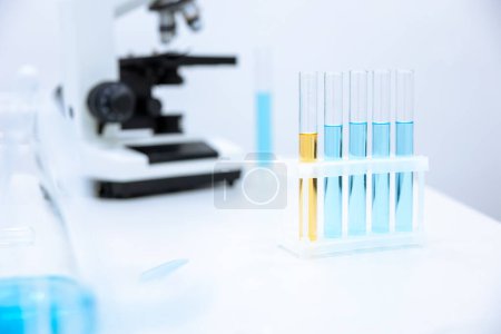 Foto de Imagen de diferentes cristalería de laboratorio con líquido de color y microscopio, microbiólogo o químico lugar de trabajo. - Imagen libre de derechos