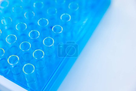Foto de Imagen de tubos de ensayo con productos químicos azules líquidos en el lugar de trabajo en laboratorio. - Imagen libre de derechos