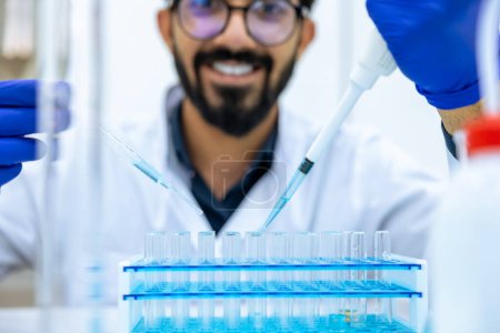 Foto de Científico masculino irreconocible usando pipeta y cuentagotas con frasco en laboratorio de ciencias médicas, investigación e investigación moderna. - Imagen libre de derechos