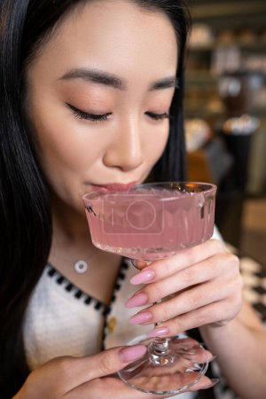 Foto de Retrato de una hermosa mujer asiática de pelo largo y calma bebiendo una bebida del vaso - Imagen libre de derechos