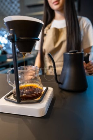 Foto de Foto recortada de un barista de pelo largo preparando una bebida con cafeína en una cafetera - Imagen libre de derechos