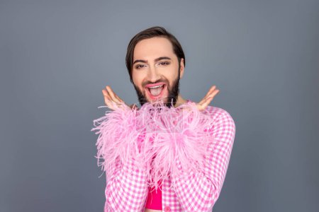 Photo for Amazed excited beautiful transgender person wearing pink clothing raised arms rejoicing saying wow posing isolated over gray background - Royalty Free Image