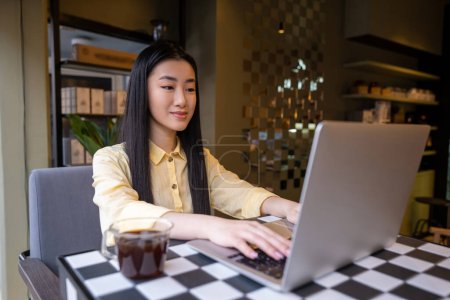 Foto de Retrato en la cintura de un trabajador remoto concentrado escribiendo algo en el portátil en la mesa de la cafetería - Imagen libre de derechos
