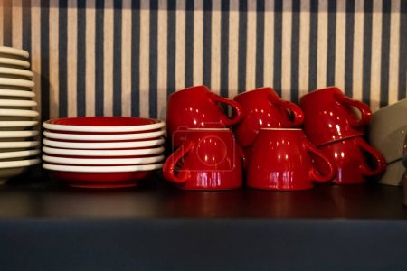 Foto de Primer plano de varios platillos apilados dispuestos en el mostrador negro junto a tazas de café de cerámica invertida vacía - Imagen libre de derechos