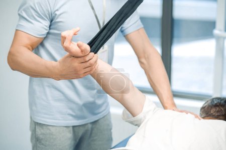 Foto de Hiperextensión del brazo. ale paciente joven que tiene una sesión de hiperestensión del brazo después de un trauma - Imagen libre de derechos