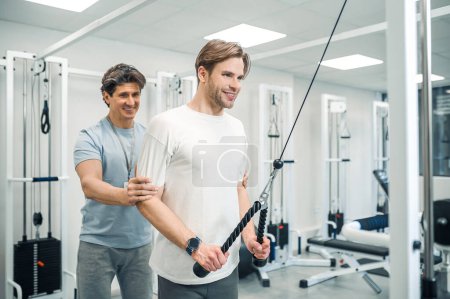 Photo for Exercising. Man having a workout in a gym in a rehabilitation center - Royalty Free Image