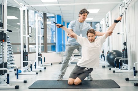 Photo for Hyperextension. Physical therapist assisting a patient while exercising on hyperextension - Royalty Free Image