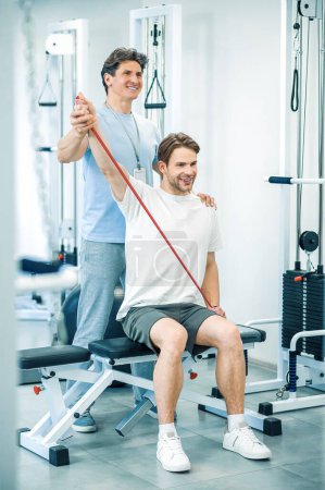 Photo for Physical therapy. Young man having a physical therapy session with a doctor - Royalty Free Image