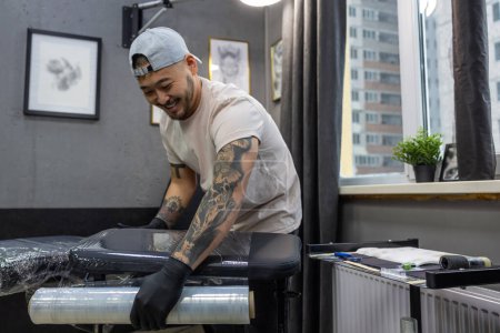 Photo for In the tattoo salon. Young man preparing for tattoo session - Royalty Free Image