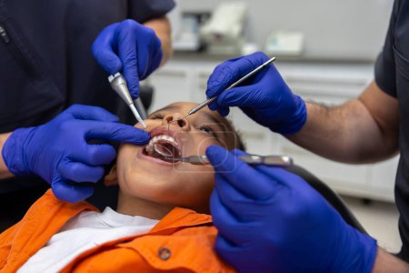 Téléchargez les photos : Médecins au travail. Gros plan des dentistes qui travaillent sur les dents d'un petit garçon - en image libre de droit