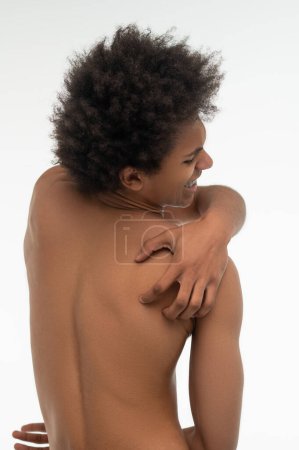Foto de Dolor de espalda. Africano americano de pelo rizado que sufre de dolor en la espalda - Imagen libre de derechos
