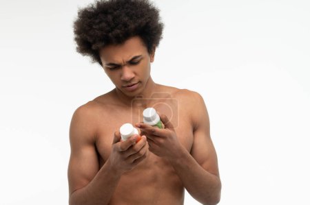 Foto de Estilo de vida saludable. Joven afroamericano eligiendo vitaminas para su salud - Imagen libre de derechos