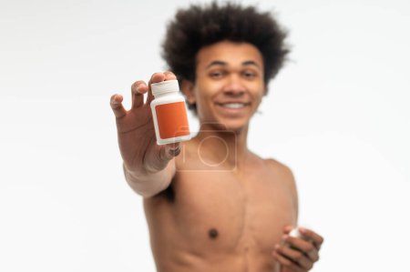 Téléchargez les photos : Mode de vie sain. Africain américain jeune homme choisissant des vitamines pour ses soins de santé - en image libre de droit