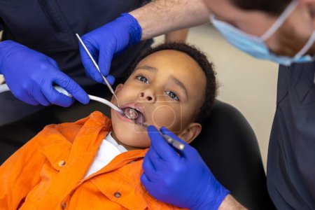 Téléchargez les photos : En dentisterie. Le dentiste et son assistant soignent les dents des garçons - en image libre de droit