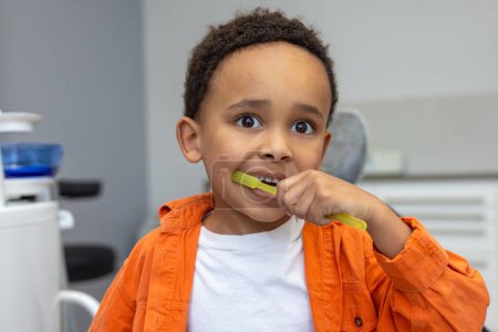 Foto de En odontología. Niño de piel oscura cepillándose los dientes - Imagen libre de derechos