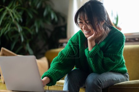 Photo for On internet. Asian young girl at home spending time online - Royalty Free Image