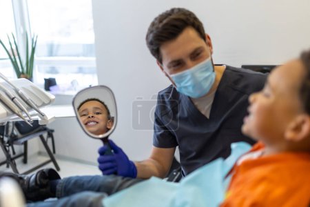 Téléchargez les photos : En dentisterie. Garçon à la peau foncée parlant au dentiste avant la séance - en image libre de droit