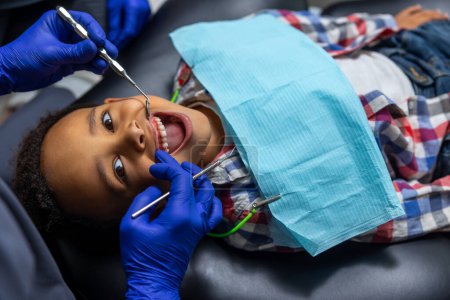 Téléchargez les photos : En dentisterie. Afro-américain garçon dents traitement de près - en image libre de droit