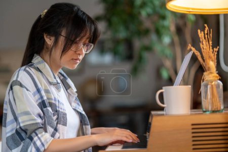 Photo for Piano-player. Girl in checkered shirt playing the piano - Royalty Free Image