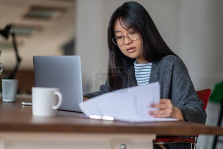 Téléchargez les photos : Travailler à la maison. Long-cheveux asiatique jeune femme travaillant dans son bureau à domicile - en image libre de droit