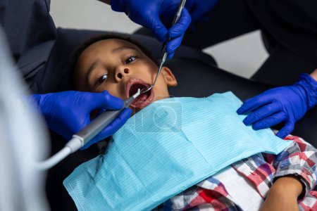 Photo for In dentistry. Dark-skinned boy having session in dentistry - Royalty Free Image