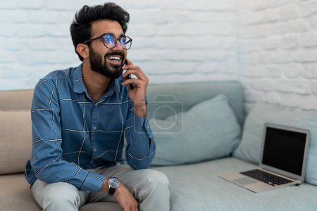 Photo for Phone call. Bearded young man talking on the phone and looking involved - Royalty Free Image