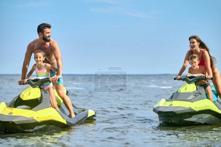 Family enjoyed active summer vacation outdoor sports and water recreation, jet-skiing on the water.