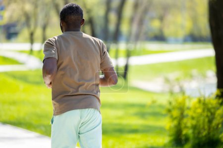 Photo for Jogging. Mature african american man jogging in the park and looking contented - Royalty Free Image