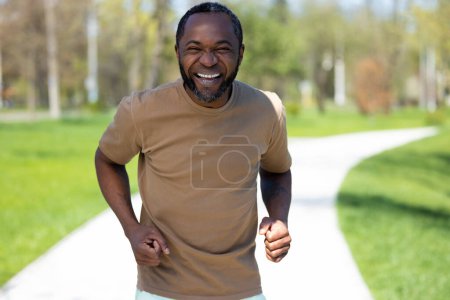 Photo for Jogging. Mature african american man jogging in the park and looking contented - Royalty Free Image