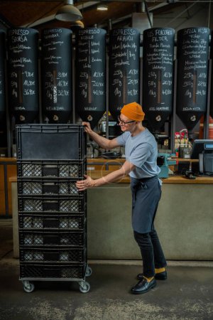 Téléchargez les photos : Barista barman portant chapeau et lunettes décharge nouveau lot de café pour le café brassage dans le café. - en image libre de droit