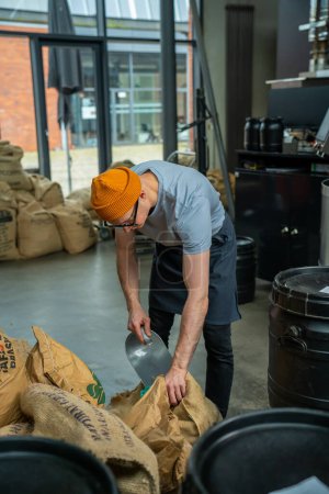 Photo for Hipster adult roasting factory worker working, pouring coffee. - Royalty Free Image