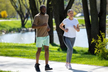 Photo for Morning run. Man and woman having a morning run together in the park - Royalty Free Image