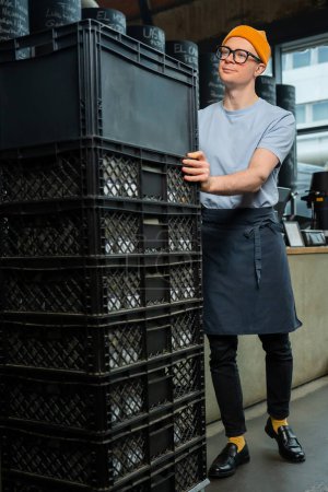 Téléchargez les photos : Adulte barista caucasien accepte nouveau lot de boîtes de déballage de café avec des marchandises, se préparant pour le processus de travail dans un café. - en image libre de droit