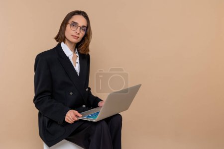 Téléchargez les photos : Une journée chargée. Femme d'affaires dans les lunettes avec un ordinateur portable à la recherche occupé - en image libre de droit