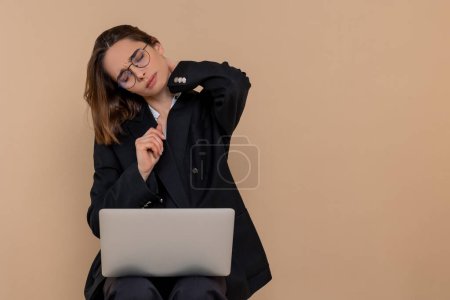 Téléchargez les photos : Stressé. Jeune femme travaillant sur ordinateur portable et regardant fatigué et stressé - en image libre de droit